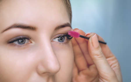 Beautiful Woman with long eyelashes in a beauty salon. Eyelash extension procedure. Lashes close upの写真素材