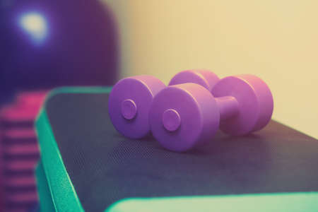 plastic dumbbells in a sports hall, close-up. Sports concept, fat burning and healthy lifestyle.の写真素材