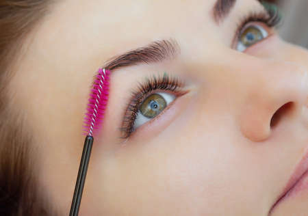 Beautiful Woman with long eyelashes in a beauty salon. Eyelash extension procedure. Lashes close upの写真素材