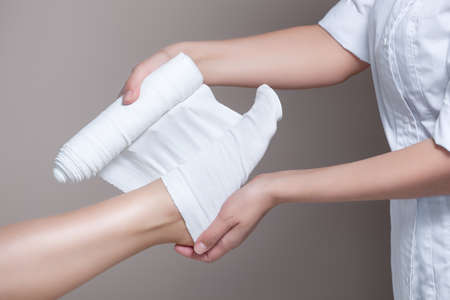 The cosmetologist wraps the leg of the customer. Anti-cellulite procedure-STYX wrap.の写真素材