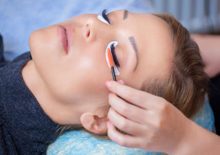 Beautiful Woman with long eyelashes in a beauty salon. Eyelash extension procedure. Lashes close upの写真素材
