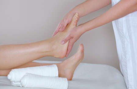 The cosmetologist wraps the leg of the customer. Anti-cellulite procedure-STYX wrap.の写真素材