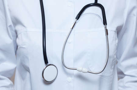 A girl doctor with a stethoscope close-up  in the clinic.の写真素材