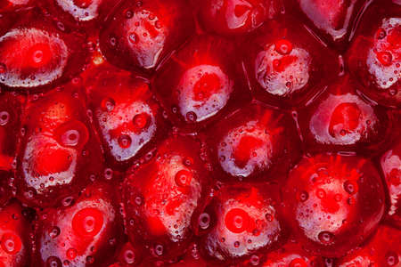 Macro slices of pomegranate fruit with drops of water on grains.の写真素材