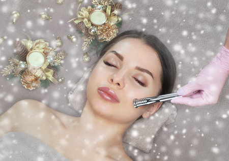 Cosmetologist does the procedure Microdermabrasion on the face of a beautiful womant. Next to her...