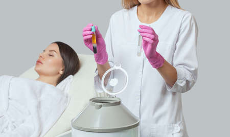 Cosmetologist does prp therapy on the face and scalp of a beautiful, young woman with clean skin in a beauty salon. There is in vitro  blood plasma, ready for injection. Cosmetology concept.の写真素材