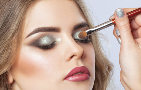 Portrait of a beautiful happy woman with long eyelashes, beautiful make-up, thick eyebrows and with...