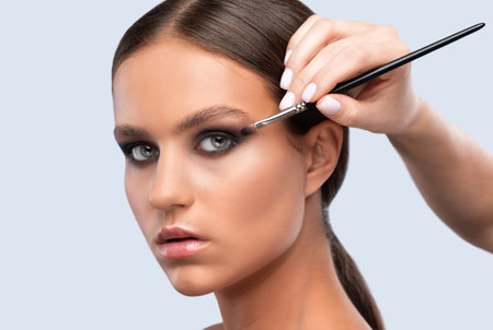 Portrait of a charming brunette woman with healthy clean skin, long hair and smokey eyes makeup....