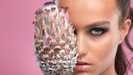 Eyes and eyebrows close up. Portrait of a beautiful teenage girl with beautiful makeup and healthy clean skin. Near the face is flower. Makeup and cosmetology concept.の写真素材