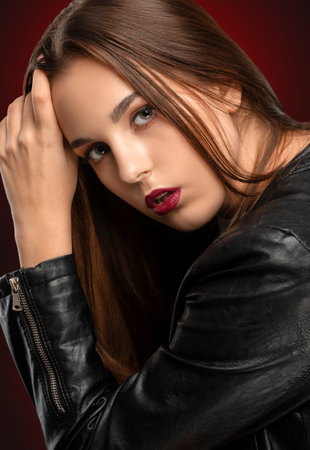 Brunette girl with beautiful makeup, with clean skin, long hair in a black leather jacket. makeup conceptの写真素材