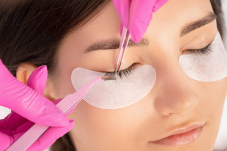 Beautiful Woman with long eyelashes in a beauty salon. Eyelash extension procedure. Lashes close up