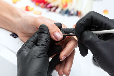 Coating nails with gel polish in the beauty salon. Professional care for hands.の写真素材