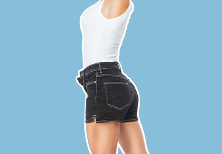 A slender girl in denim shorts and a white T-shirt on a blue background.