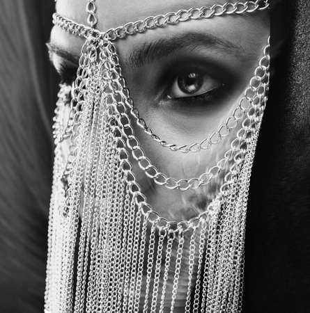 Beautiful girl with beautiful makeup and jewelry on her face.Black and white photo.の写真素材