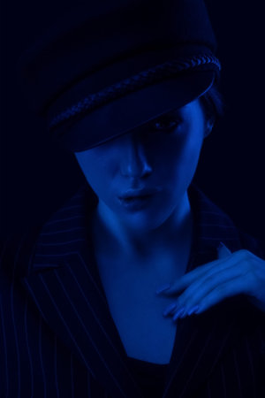 Portrait of a beautiful elegant girl in a beret and suit. Photo in neon style.