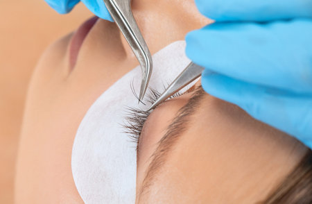 Beautiful Woman with long eyelashes in a beauty salon. eyelash extension procedure. Lashes close up