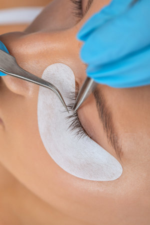 Beautiful Woman with long eyelashes in a beauty salon. eyelash extension procedure. Lashes close up
