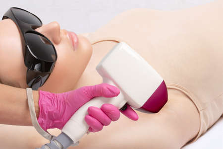 Elos epilation hair removal procedure on a woman's body. Beautician doing laser rejuvenation in a beauty salon. Removing unwanted body hair. Hardware ipl cosmetologyの写真素材
