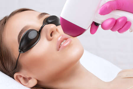 Elos epilation hair removal procedure on a woman's body. Beautician doing laser rejuvenation in a beauty salon. Removing unwanted body hair. Hardware ipl cosmetologyの写真素材