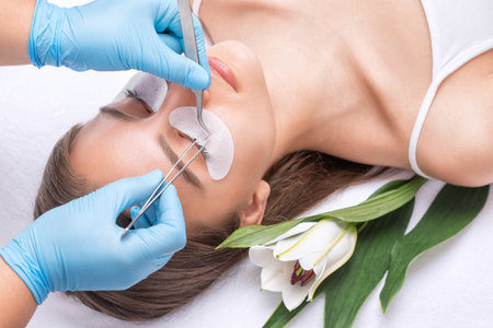 Beautiful Woman with long eyelashes in a beauty salon. eyelash extension procedure. Lashes close upの写真素材