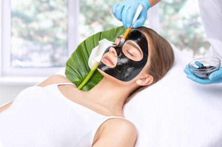 Cosmetologist doing carbon peeling procedure to beautiful blue-eyed girl in a beauty salon. hardware cosmetology treatmentの写真素材