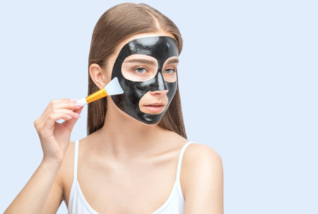 Cosmetologist doing carbon peeling procedure to beautiful girl in a beauty salon. hardware cosmetology treatment.の写真素材