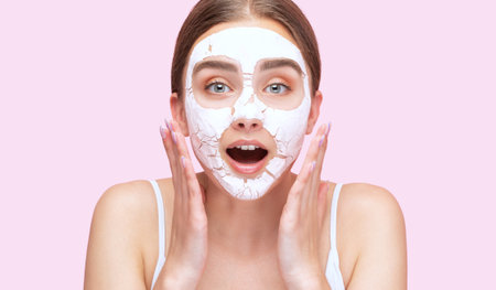 Beautician makes a face mask of a woman to rejuvenate the skin. Cosmetology treatment of problem skin on the face and body.の写真素材