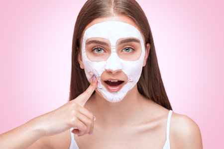 Beautician makes a face mask of a woman to rejuvenate the skin. Cosmetology treatment of problem skin on the face and body.の写真素材