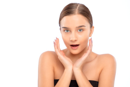 Beautiful young woman with clean skin holds her hands near her face. Makeup and healthy clear skin.の写真素材