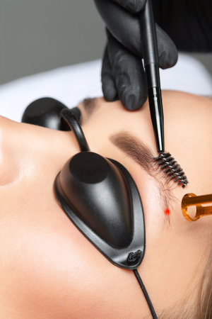 Removal of permanent makeup on the eyebrows.Carbon face peeling in a beauty salon. hardware cosmetology treatment.の写真素材