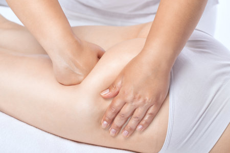 Masseur makes anti-cellulite massageon the legs, thighs, hips and buttocks in the spa. Overweight treatment, body sculpting.Cosmetology and massage concept.の写真素材