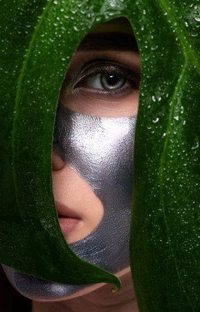 Girl applying a face mask to rejuvenate the skin. Cosmetology treatment of problem skin on the face...