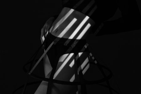 Girl in a petticoat. Belly and hips of a beautiful young woman in a black undershirt close-up. black and white photo.の写真素材