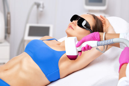 Elos epilation hair removal procedure on a woman's body. Beautician doing laser rejuvenation in a beauty salon. Removing unwanted body hair. Hardware ipl cosmetologyの写真素材