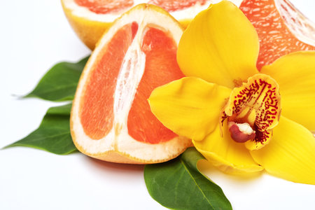 Ripe grapefruit and bright yellow orchid. The concept of healthy food, sports, active lifestyle.の写真素材