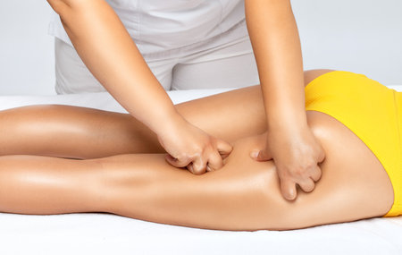 Masseur makes anti-cellulite massage on the legs, thighs, hips and buttocks in the spa. Overweight treatment, body sculpting.Cosmetology and massage concept.の写真素材