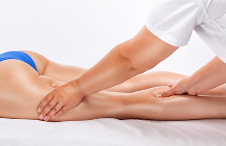 Masseur makes anti-cellulite massage on the legs, thighs, hips and buttocks in the spa. Overweight treatment, body sculpting.Cosmetology and massage concept.の写真素材