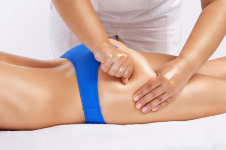 Masseur makes anti-cellulite massage on the legs, thighs, hips and buttocks in the spa. Overweight treatment, body sculpting.Cosmetology and massage concept.の写真素材