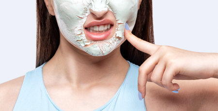 Beautician makes a face mask of a woman to rejuvenate the skin. Cosmetology treatment of problem skin on the face and body.の写真素材
