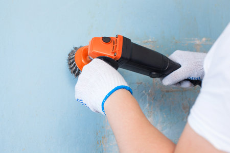 The builder holds in hands Angle grinder. Repair work, interior decoration of walls.の写真素材