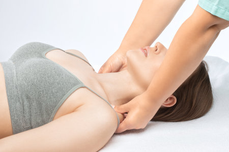 Masseur makes a relaxing massage on the neck, shoulders, back and collarbones of a young beautiful woman in a spa. Treatment for back pain.の写真素材