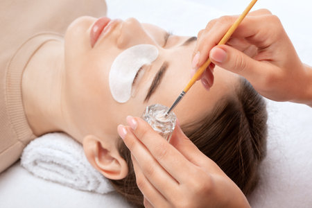 Make-up artist makes the procedure of lamination and dyeing of eyelashes to a beautiful woman in a beauty salon. Eyelash extensions. eyelash liftingの写真素材