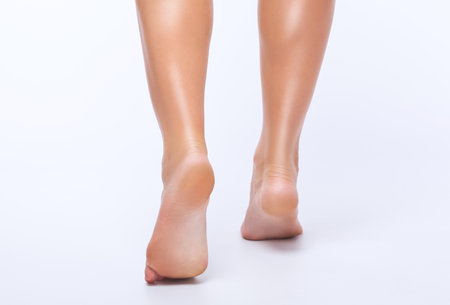 Beautiful slender legs of a woman on a white background. Feet close up. Podiatrist appointment.の写真素材