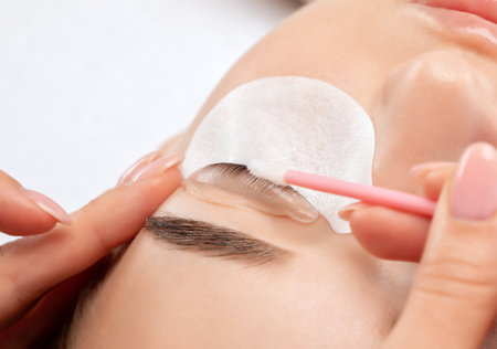 Make-up artist makes the procedure of lamination and dyeing of eyelashes to a beautiful woman in a beauty salon. Eyelash extensions. eyelash liftingの写真素材