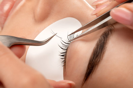 Beautiful Woman with long eyelashes in a beauty salon. eyelash extension procedure. Lashes close upの写真素材