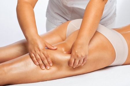 Masseur makes anti-cellulite massageon the legs, thighs, hips and buttocks in the spa. Overweight treatment, body sculpting.Cosmetology and massage concept.の写真素材