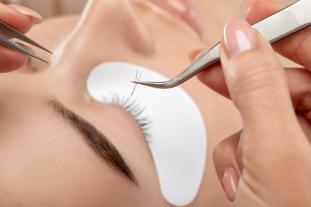 Beautiful Woman with long eyelashes in a beauty salon. eyelash extension procedure. Lashes close upの写真素材