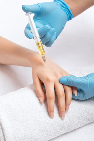 The cosmetologist makes injections against sagging on the hands of a woman. Women's cosmetology, skin care.の写真素材