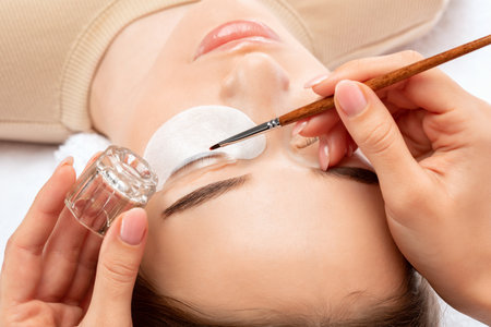 Make-up artist makes the procedure of lamination and dyeing of eyelashes to a beautiful woman in a beauty salon. Eyelash extensions. eyelash liftingの写真素材