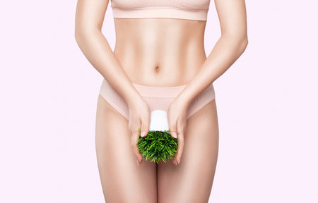 Women Health. A slender woman in white underwear with a green flower. rejuvenation in a beauty salon. Removing unwanted body hair.の写真素材